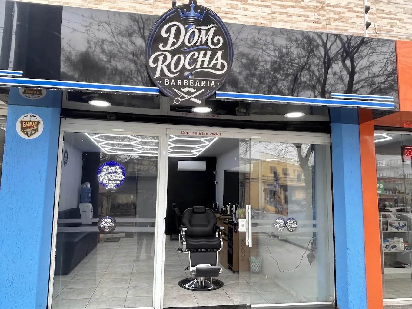 Fachada da Barbearia Dom Rocha com o letreiro do emblema